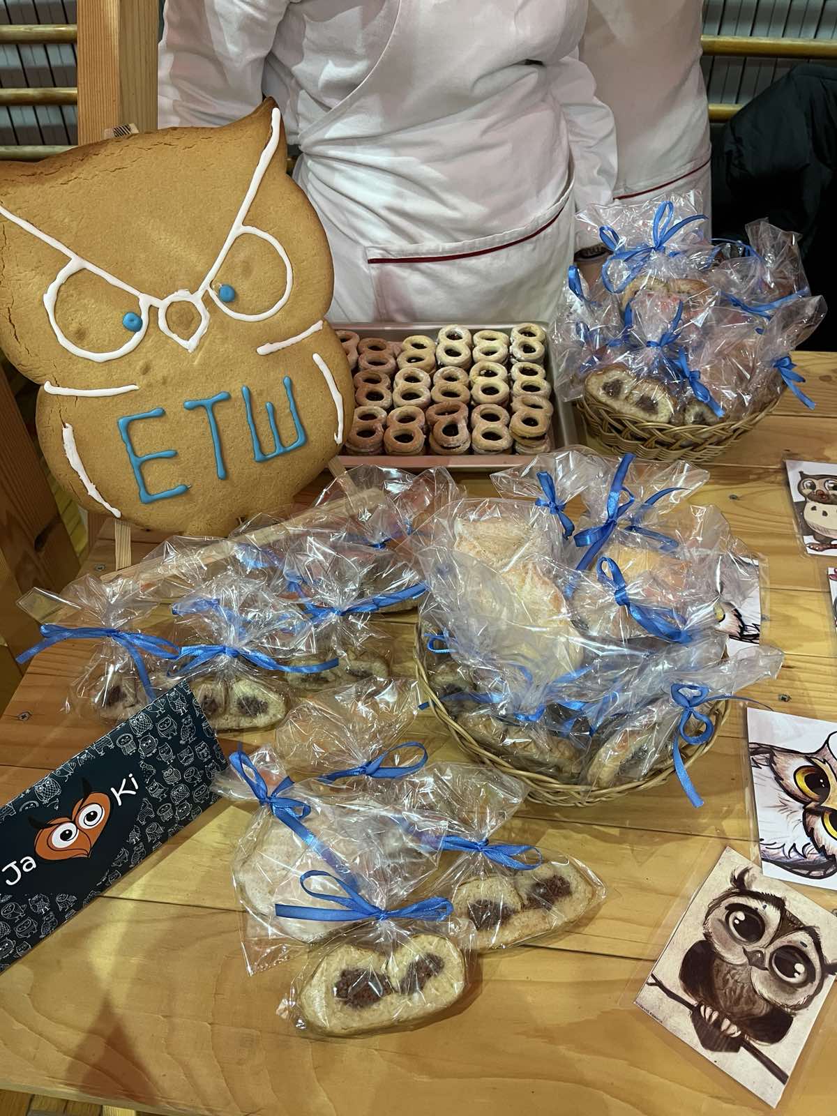 A table with bags of cookies and a cookie in it

Description automatically generated