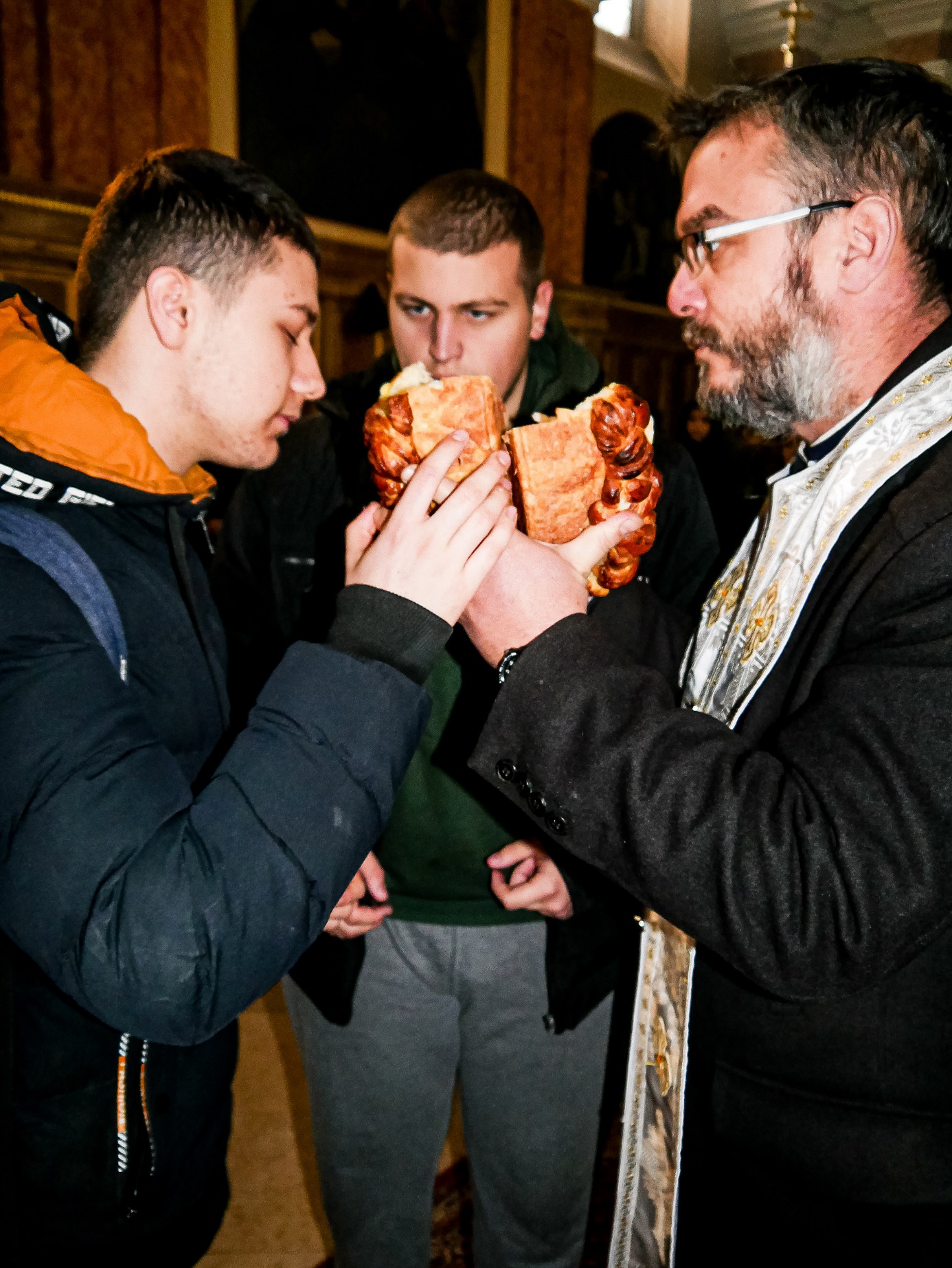 A group of men eating bread

Description automatically generated