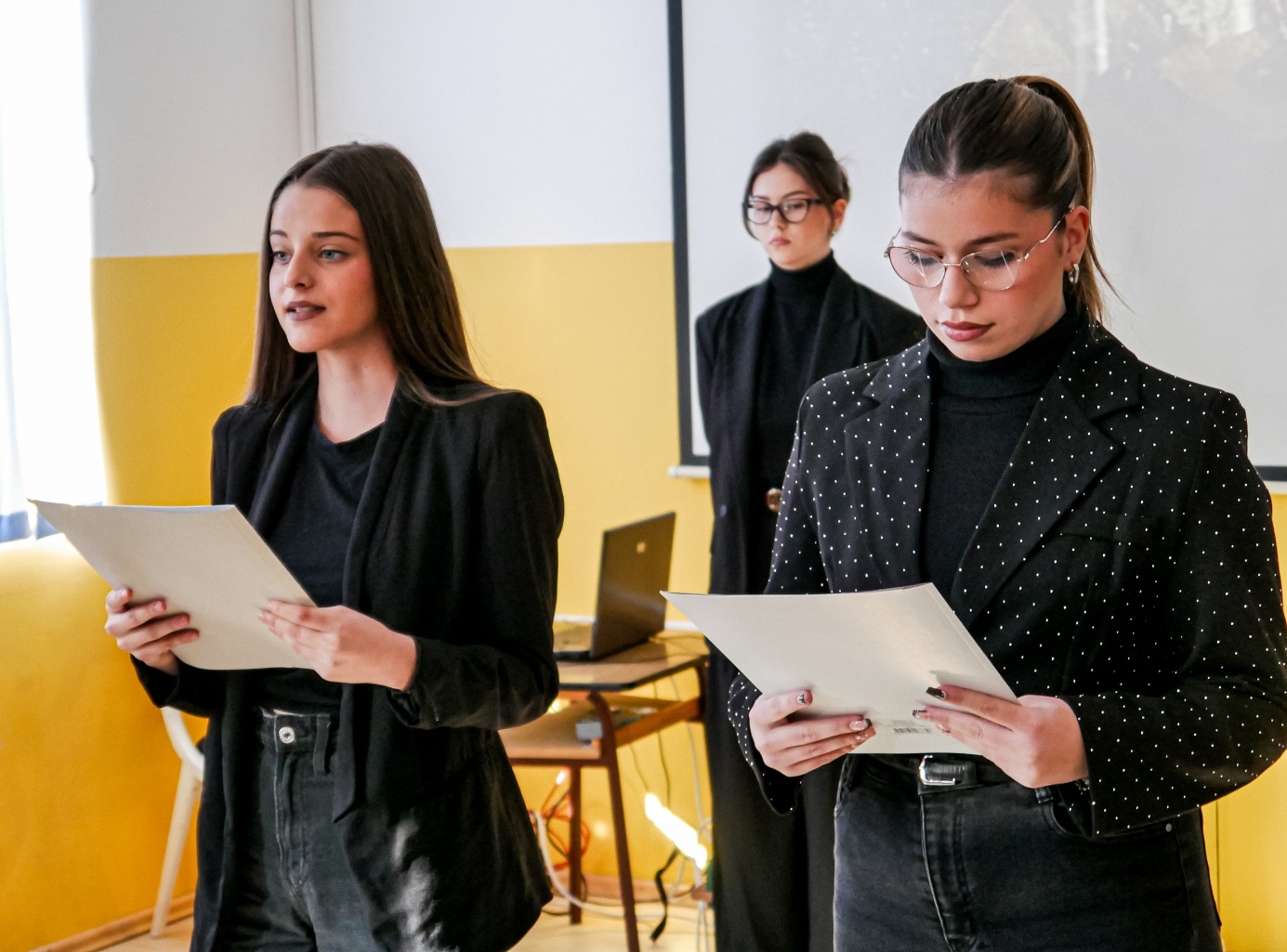 A group of women standing in a room

Description automatically generated